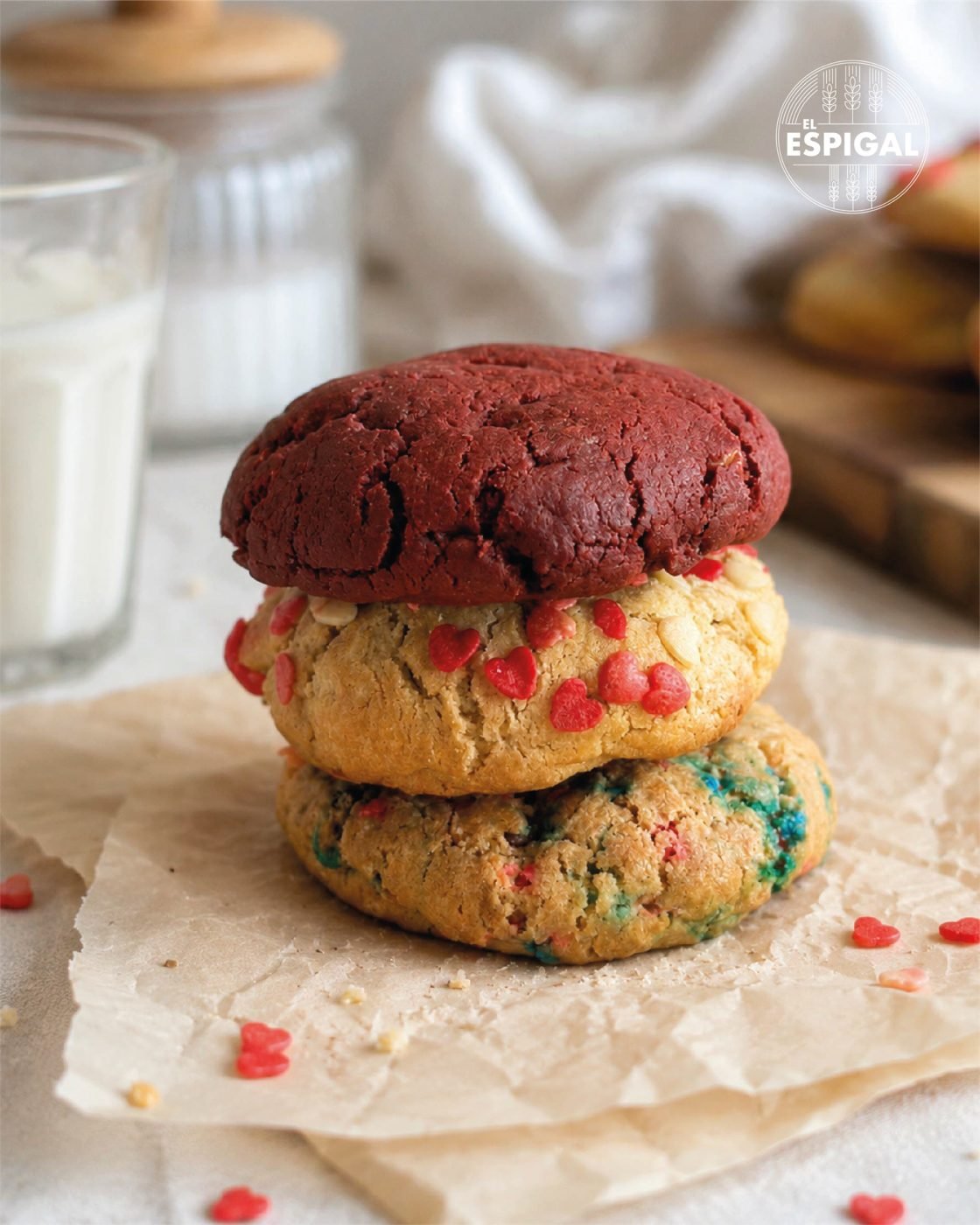 Cookies red velvet y de chips de colores El Espigal junto a un vaso de leche